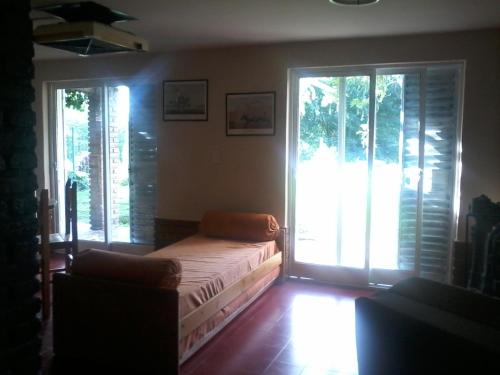 1 dormitorio con 1 cama y 2 ventanas grandes en Aires de San Antonio en San Antonio de Arredondo