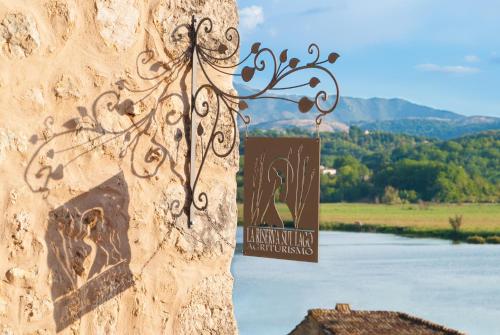 a sign on the side of a wall next to a river at La Casa Sul Lago in Posta Fibreno