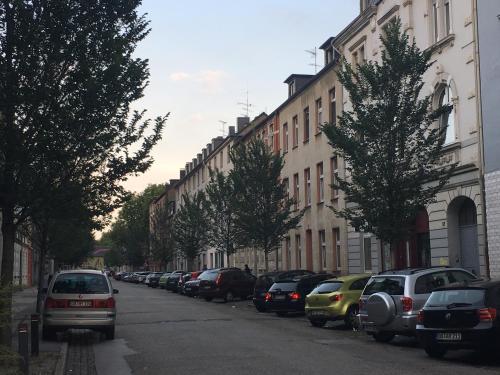 een straat met auto's aan de zijkant van een gebouw bij A&H Apartment in Oberhausen