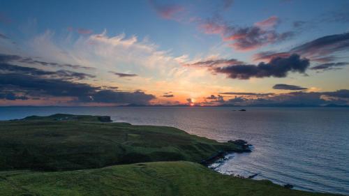 a sunset over a body of water with the ocean at The Homer in Kilmuir