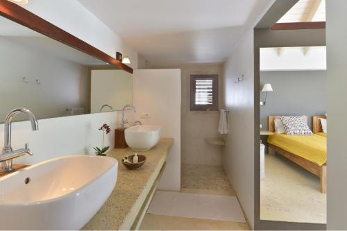 a bathroom with a sink and a bed in a room at Villa Jali in Gustavia