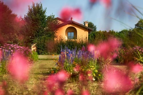 una casa en medio de un jardín con flores en Al Canton Agriturismo di Design, en San Michele al Tagliamento