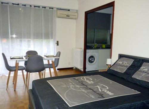 une chambre avec un lit et une table avec des chaises dans l'établissement Appartement Perpignan Centre Place Catalogne, à Perpignan
