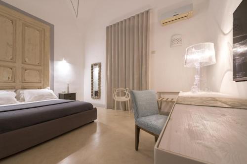 サンニコーラにあるVilla Starace - Appartamento Buongiornoのベッドルーム1室(ベッド1台、椅子、デスク付)