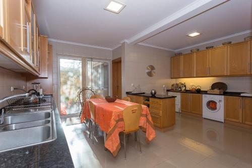 a kitchen with a table with an orange table cloth on it at 43 House Azores in Ponta Delgada