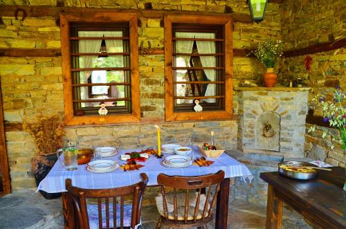 einen Tisch mit einem blauen Tischtuch und Kerzen darauf in der Unterkunft Kalinia Guesthouse B&B in Kovachevitsa