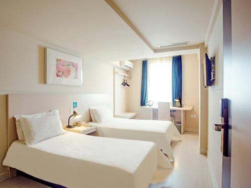 Jingjiang Inn Taiyuan Fuxi Street Wanda Plaza tesisinde bir odada yatak veya yataklar