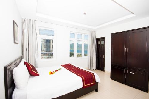 Habitación blanca con cama y ventana en Misa Hotel Da Nang, en Da Nang