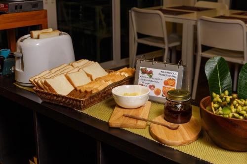 a table with bread and a bowl of butter and other food at U Tiny Boutique Hotel Suvarnabhumi Bangkok - SHA Plus in Lat Krabang