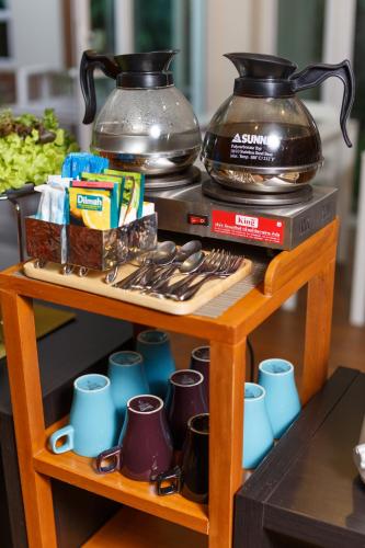 a table with cups and mugs on top of it at U Tiny Boutique Hotel Suvarnabhumi Bangkok - SHA Plus in Lat Krabang