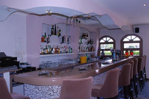 eine Bar in einem Restaurant mit einer Reihe von Stühlen in der Unterkunft SeaBird Hotel in Moraḯtika