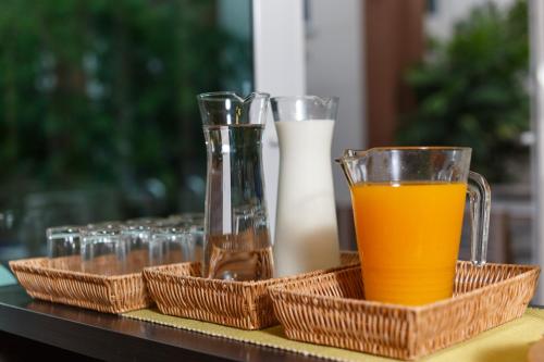 a tray of glasses and a glass of orange juice at U Tiny Boutique Hotel Suvarnabhumi Bangkok - SHA Plus in Lat Krabang