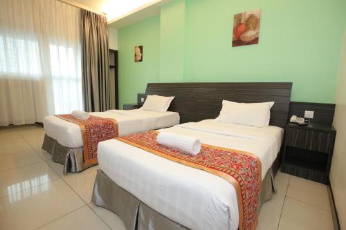 a hotel room with two beds in a room at Ipoh Downtown Hotel in Ipoh