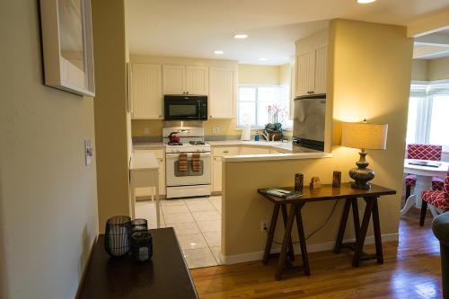 uma cozinha com armários brancos e uma mesa com um candeeiro em Aurora Park Cottages em Calistoga