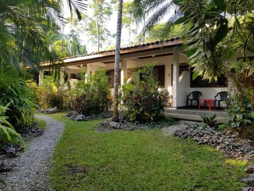 une villa avec un jardin et un chemin menant à celle-ci dans l'établissement Piscina Natural on the Sea, à Cahuita
