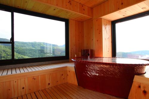 a room with two large windows in a wooden cabin at Hotel Higashidate in Yamanouchi