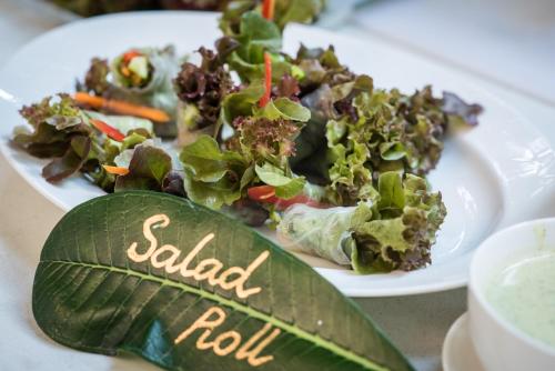 a plate of salad on a table with a leaf at U Tiny Boutique Hotel Suvarnabhumi Bangkok - SHA Plus in Lat Krabang