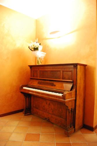a piano in a room with a flower on the wall at Queen Hotel in San Giovanni Teatino