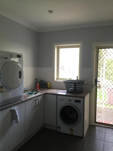 a kitchen with a washing machine and a window at No 96 in Melbourne