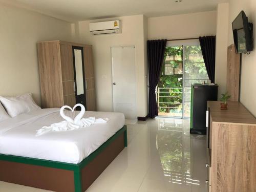 a hotel room with a bed with a heart on it at The Wisdom Residence in Bung Kan