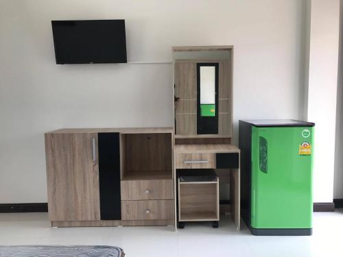a room with a green refrigerator and wooden cabinets at The Wisdom Residence in Bung Kan