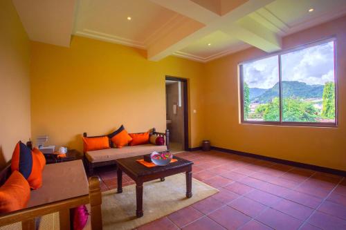a living room with a couch and a large window at Temple Tree Resort & Spa, Pokhara in Pokhara