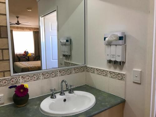 a bathroom with a sink and a mirror at Starlight Motor Inn in Roma