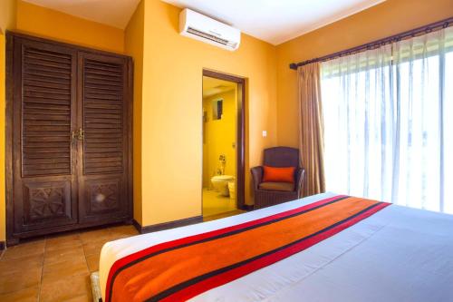 a bedroom with a bed and a window and a bathroom at Temple Tree Resort & Spa, Pokhara in Pokhara