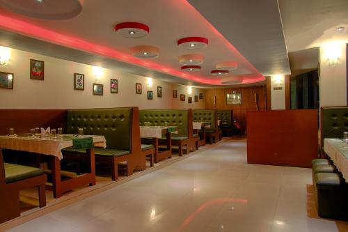 a restaurant with tables and chairs and a red ceiling at Hotel Le Primula in Gangtok