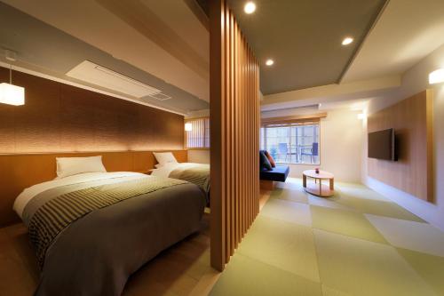 a hotel room with two beds and a television at Kami no yama Azumaya in Kaminoyama