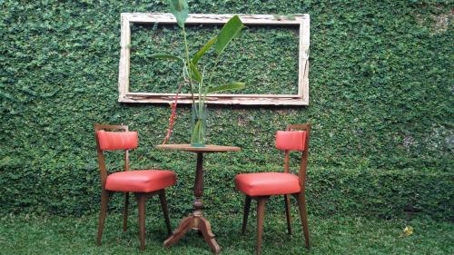 two chairs and a table with a plant in a vase at Griya Sriwedari in Ubud