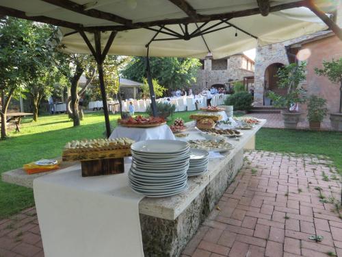 a buffet of food on a table under an umbrella at B&B Le Caselle "Il Baraccotto" in Lucignano