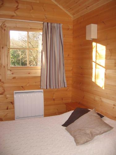 a bedroom with a bed in a wooden room at La Simonette in Dienville