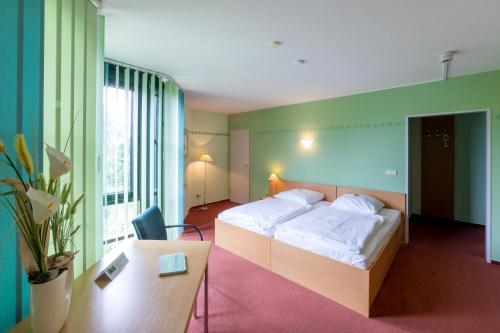 a hotel room with a bed and a desk and a room at LEAG Konferenzcenter Schulungs- und Tagungshotel im Spreewald in Lübbenau