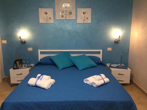 Un dormitorio con una cama azul con toallas. en Villa Luisa, en Tropea