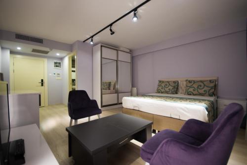 a bedroom with a bed and two chairs and a table at EPS Suite in Istanbul