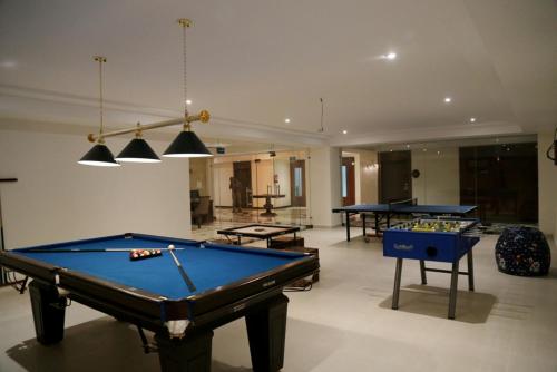 a pool table in a room with two tables at LP Vilas in Dehradun