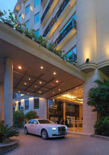 a white car parked in front of a building at Goldfinch Hotel Bangalore in Bengaluru