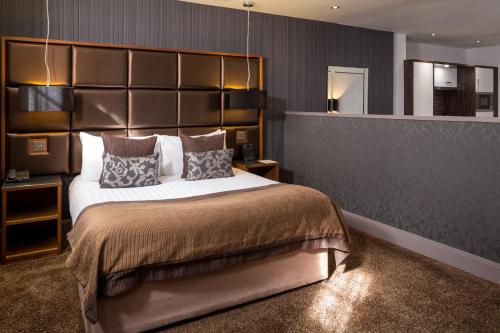 a bedroom with a large bed with a large headboard at Roomzzz Newcastle City in Newcastle upon Tyne