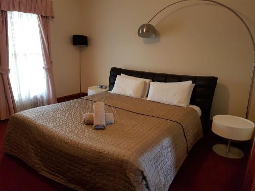 1 dormitorio con 1 cama con 2 toallas en King Street Apartments, en Warrnambool