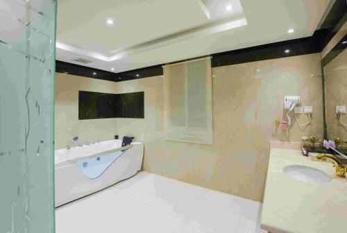 a bathroom with a tub and a sink at Rest Night Serviced Apartments- AlHamra in Riyadh