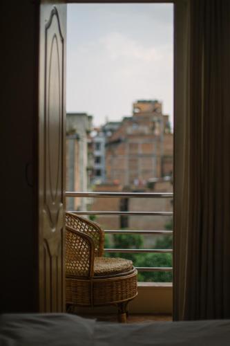 a chair on a balcony with a view of a city at Tajaa Pha The Heritage Home in Pātan