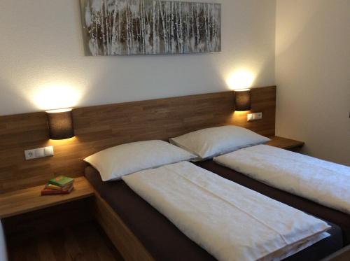 two beds in a room with two lamps on the wall at Haus Hannah in Ladis