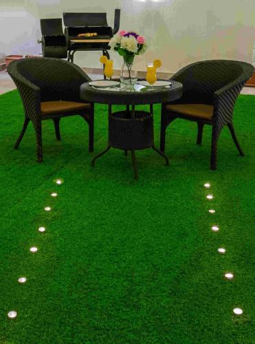 a table with a vase of flowers and a piano at Rest Night Serviced Apartments- AlHamra in Riyadh