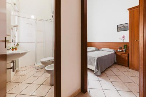 a bedroom with a bed and a toilet and a sink at Hotel Bellavista in Maierà