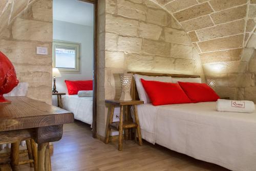 1 dormitorio con 2 camas y pared de piedra en LecceHome, en Lecce