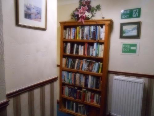 a book shelf filled with books in a room at Dinorben Arms Hotel in Amlwch