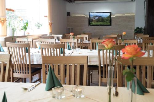 ein Restaurant mit Tischen und Stühlen mit Blumen darauf in der Unterkunft Hotel Promenade in Bad Steben