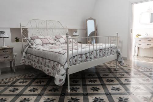 a bedroom with a metal bed with a mirror at Masseria Luco in Martina Franca