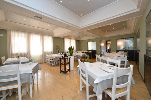 a dining room with white tables and white chairs at Locanda Grego in Bolzano Vicentino